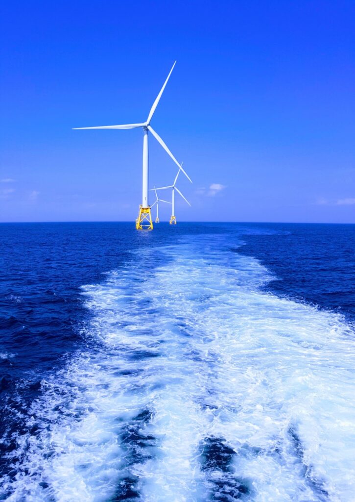 Windmills in the ocean with blue skies
